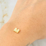Herraje Letra M 0.45gr / 0.6cm / Oro Amarillo 18K © Herraje Letra M 0.45gr / 0.6cm / Oro Amarillo 18K ©