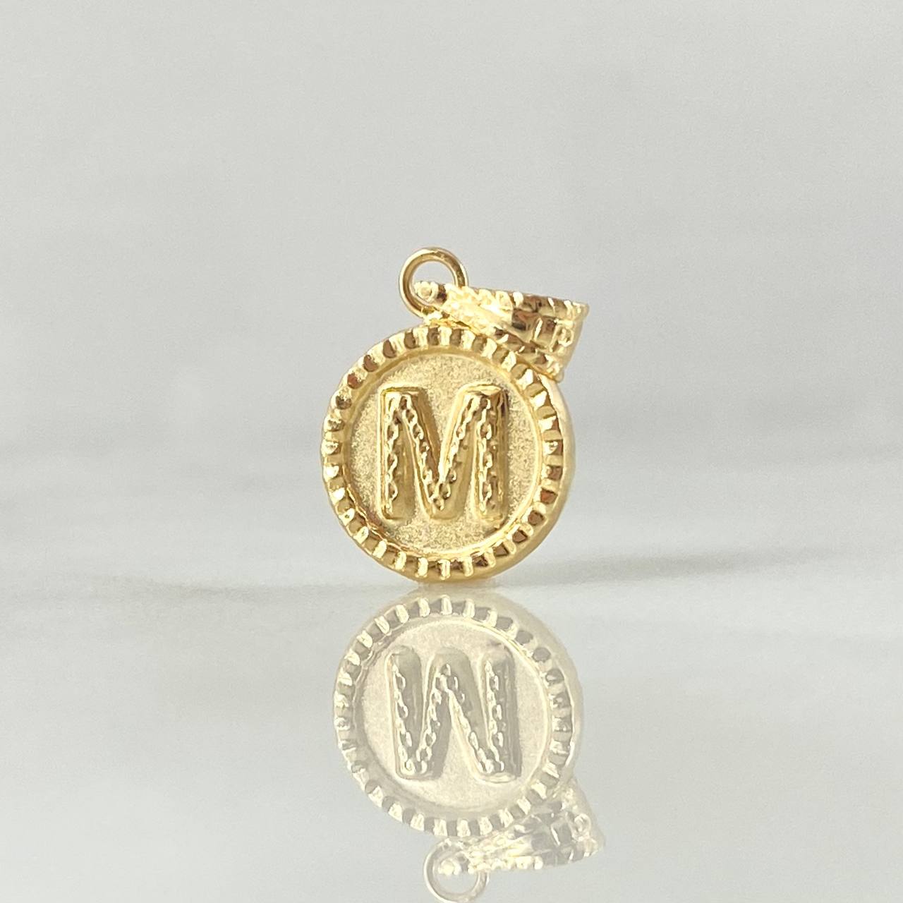 Dije Letra M 0.55gr / 1.7cm / Circulo Cargador Bordeado Oro Amarillo 18K