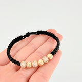 Pulsera Tejida Negra Bolas de Fuego Bolas Diamantadas Oro Amarillo 18K