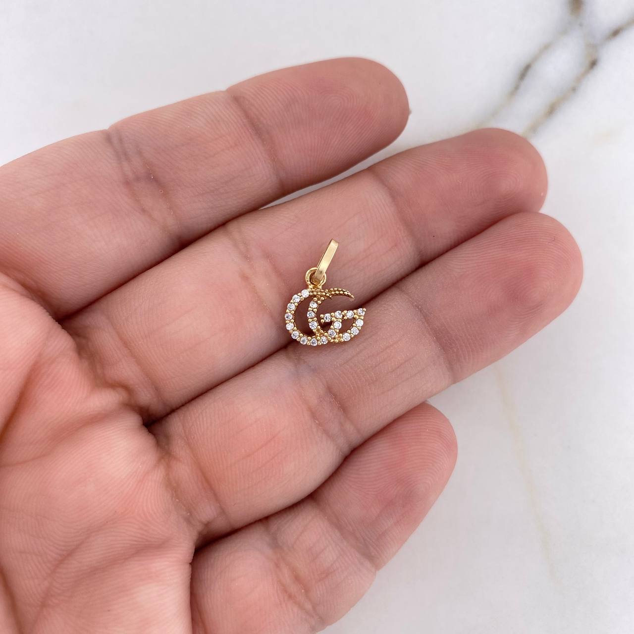Dije GG 0.55gr / 1.4cm / Circones Blancos Oro Amarillo 18K $