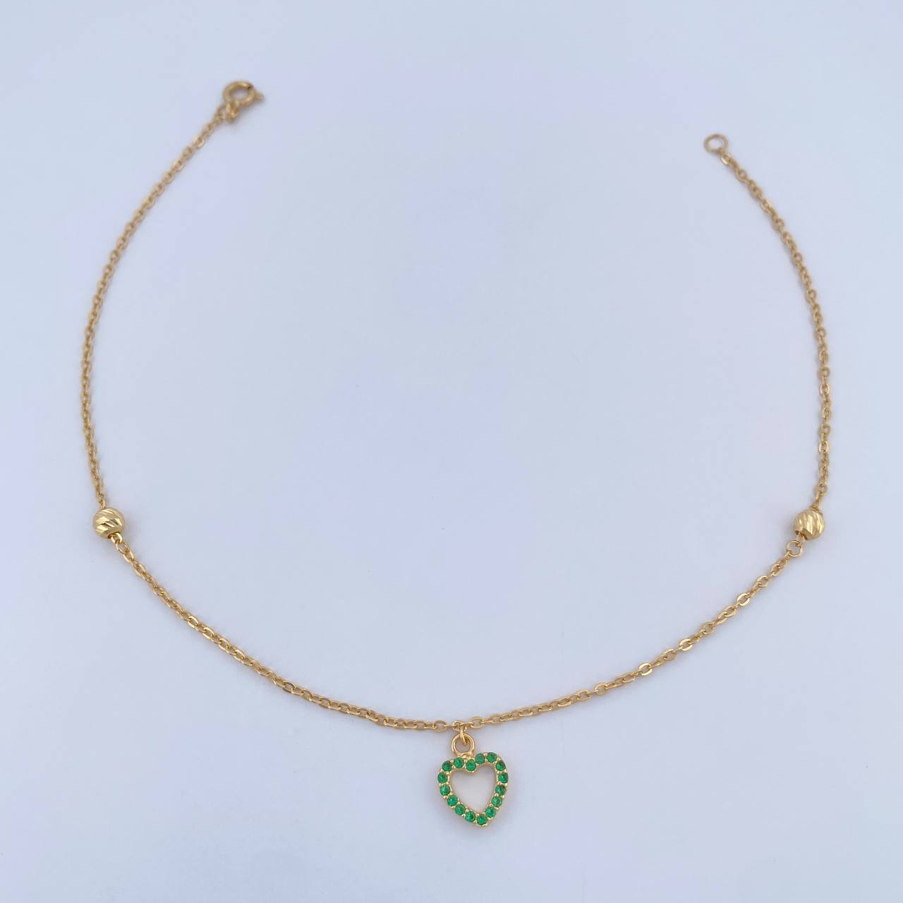 Tobillera Aro Seguido Silueta Corazon 2.05gr / 25.1cm / 4mm Bolas Diamantadas Circones Verdes Oro Amarillo 18K &