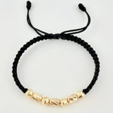 Pulsera Negra Cilindros Interceptos 7und / 4mm-5mm Oro Amarillo 18K *