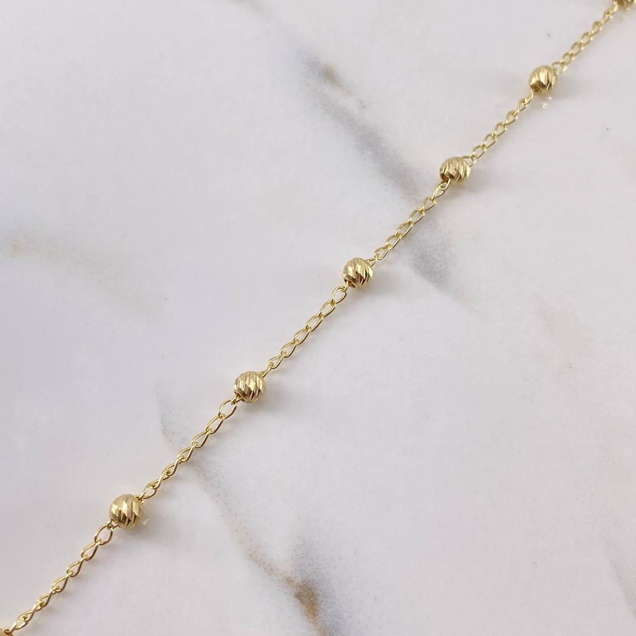 Tobillera Tipo Militar 2.5gr / 25.6cm / 3.6mm Bolas Diamantadas Oro Amarillo 18K $