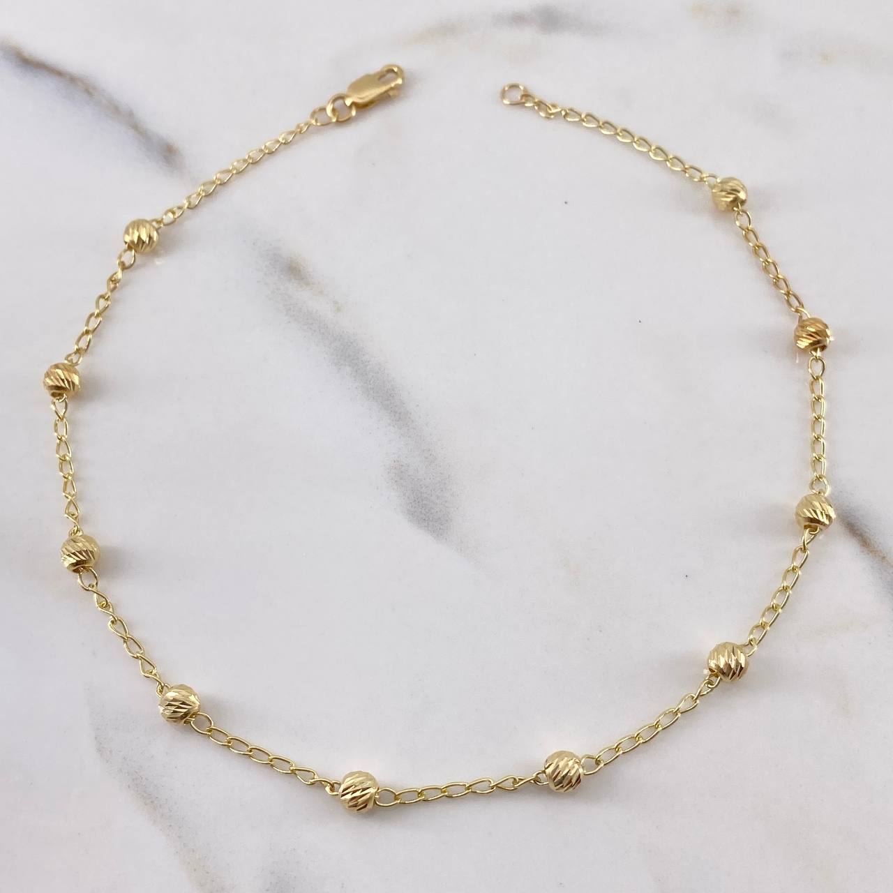 Tobillera Tipo Militar 2.5gr / 25.6cm / 3.6mm Bolas Diamantadas Oro Amarillo 18K $