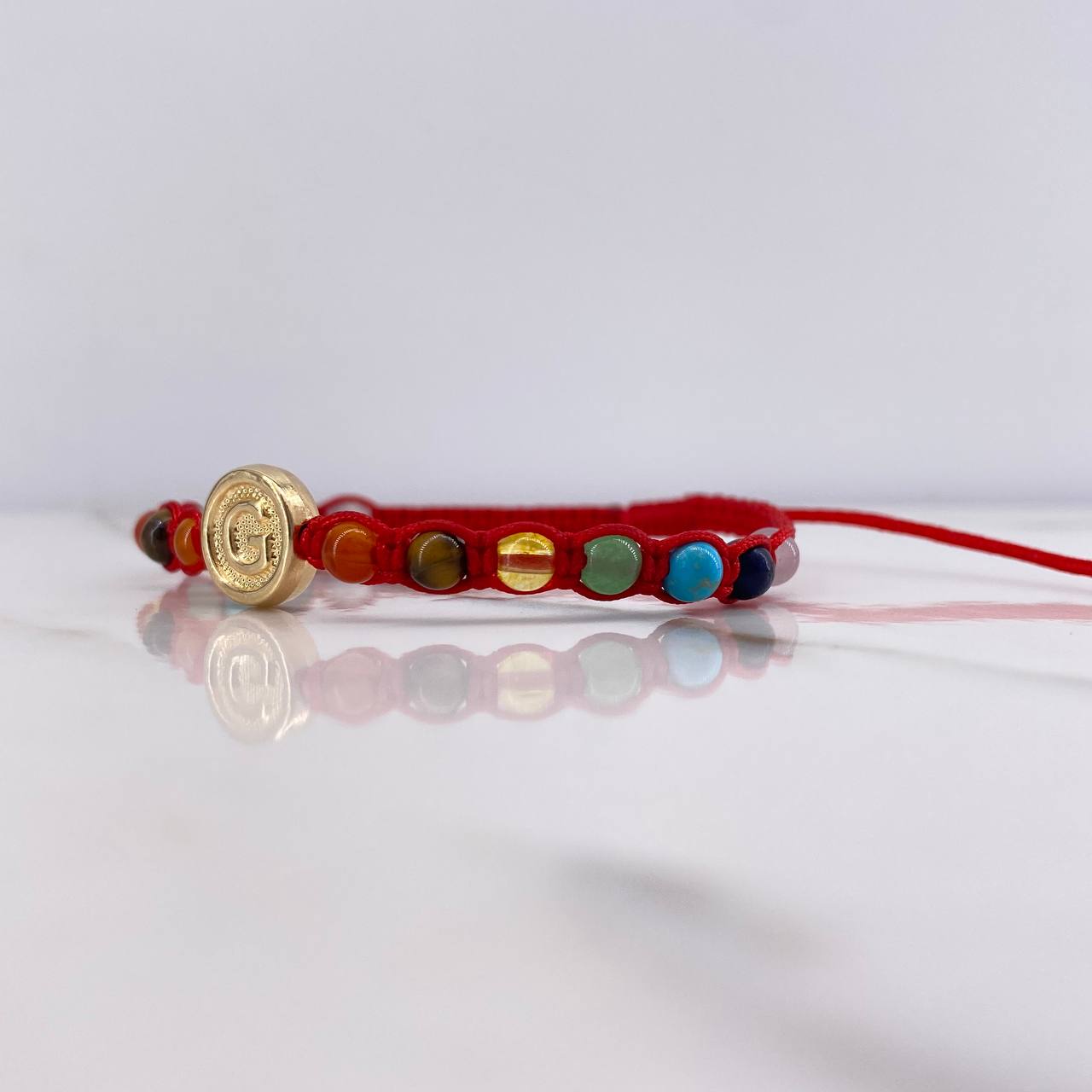 Pulsera Roja Herraje Letra G 0.55gr / 1cm / 4mm Tambor 7 Chakras Oro Amarillo $