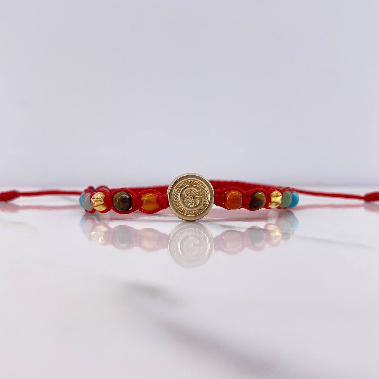 Pulsera Roja Herraje Letra G 0.55gr / 1cm / 4mm Tambor 7 Chakras Oro Amarillo $