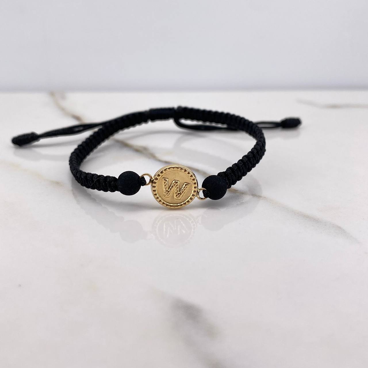 Pulsera Negra Herraje Letra W 0.55gr / 1.5cm / 5mm Troquelado Bolas Neoprenos Negras Oro Amarillo $