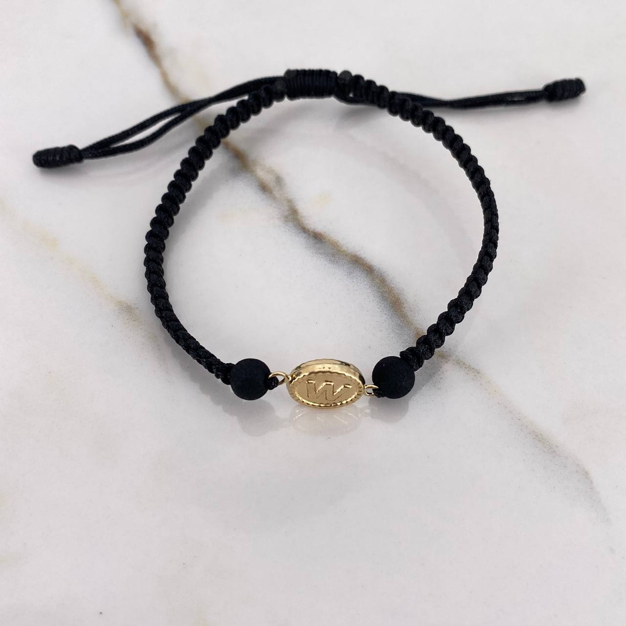 Pulsera Negra Herraje Letra W 0.55gr / 1.5cm / 5mm Troquelado Bolas Neoprenos Negras Oro Amarillo $