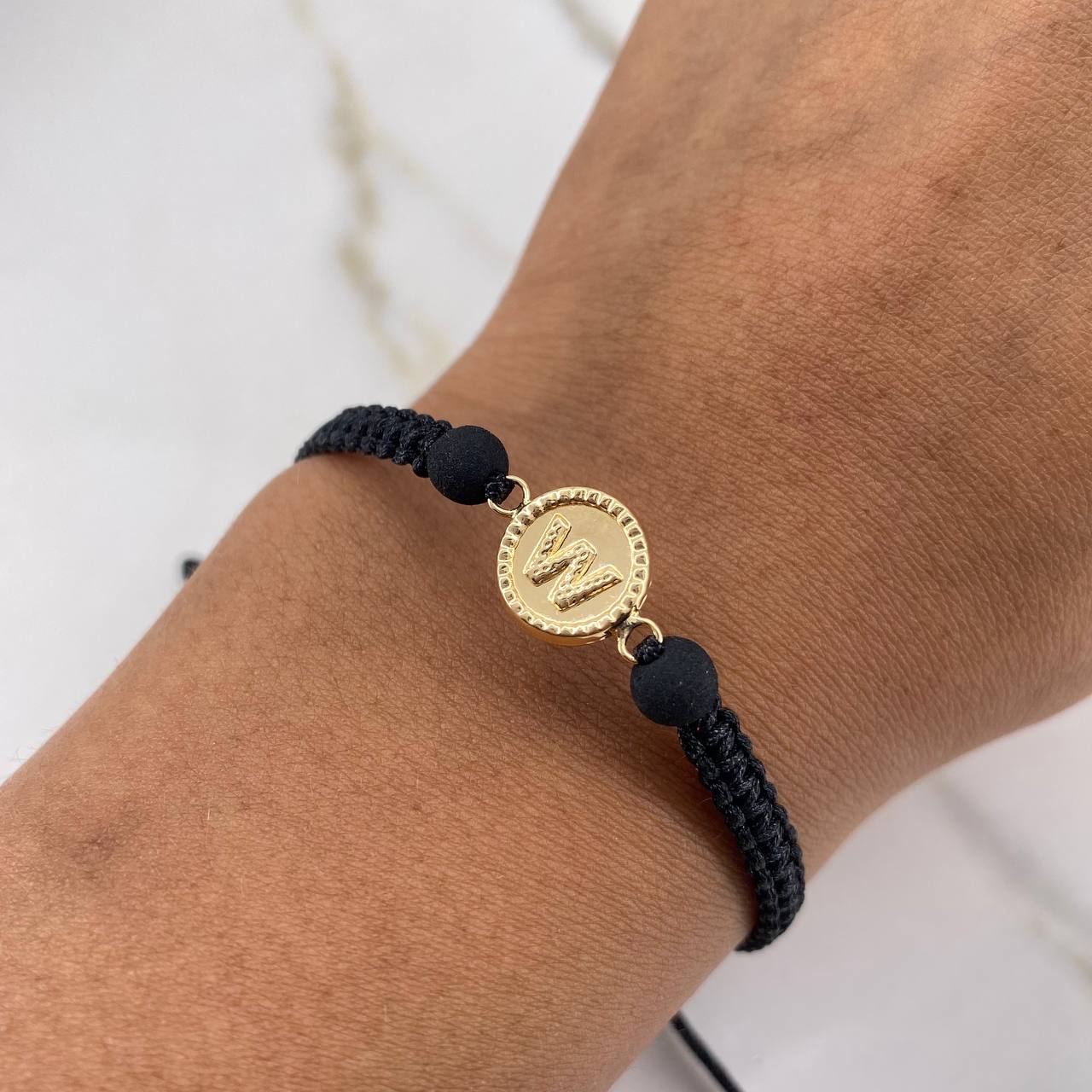 Pulsera Negra Herraje Letra W 0.55gr / 1.5cm / 5mm Troquelado Bolas Neoprenos Negras Oro Amarillo $