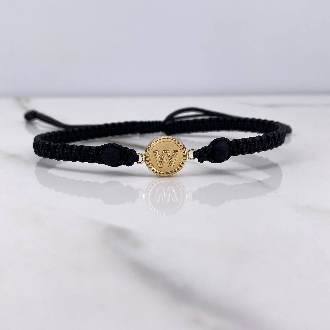 Pulsera Negra Herraje Letra W 0.55gr / 1.5cm / 5mm Troquelado Bolas Neoprenos Negras Oro Amarillo $