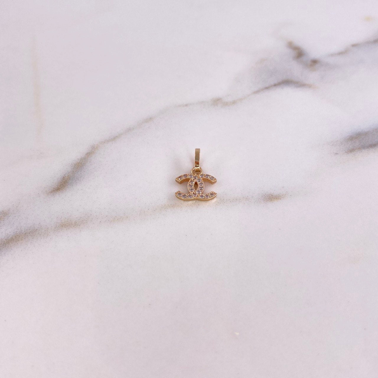 Dije CC 0.5gr / 1.4cm / Circones Blancos Oro Amarillo $