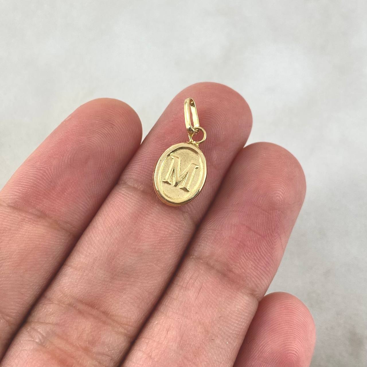 Dije Letra M Ovalada 0.45gr / 1.8cm / Troquelada Oro Amarillo ©