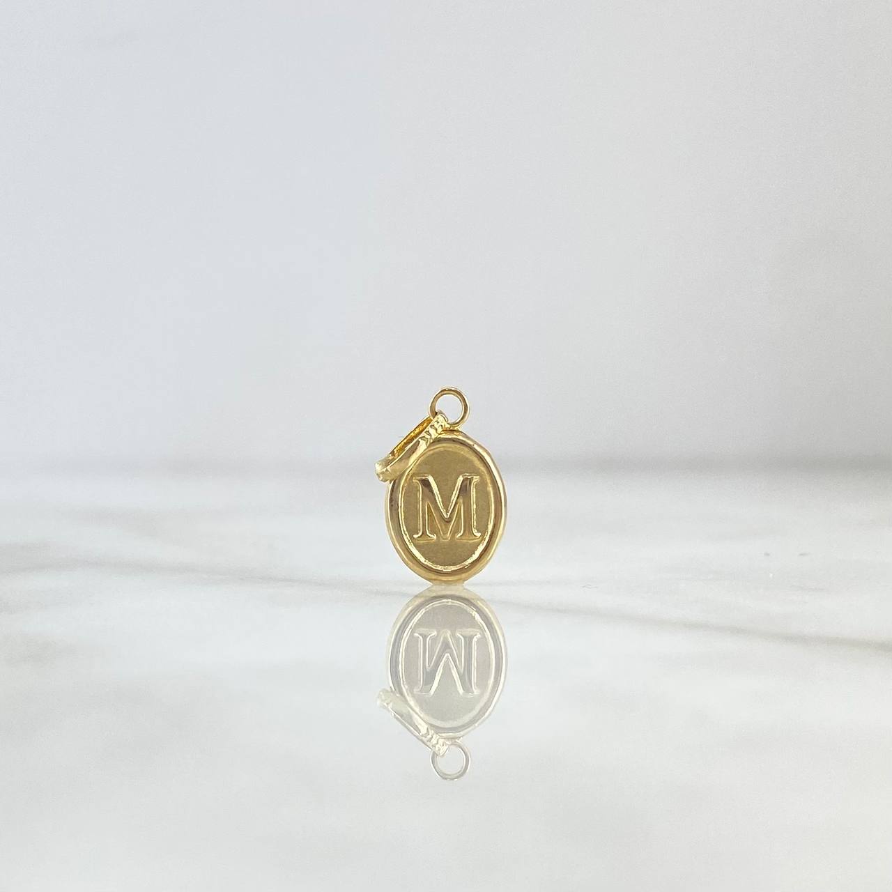 Dije Letra M Ovalada 0.45gr / 1.8cm / Troquelada Oro Amarillo ©