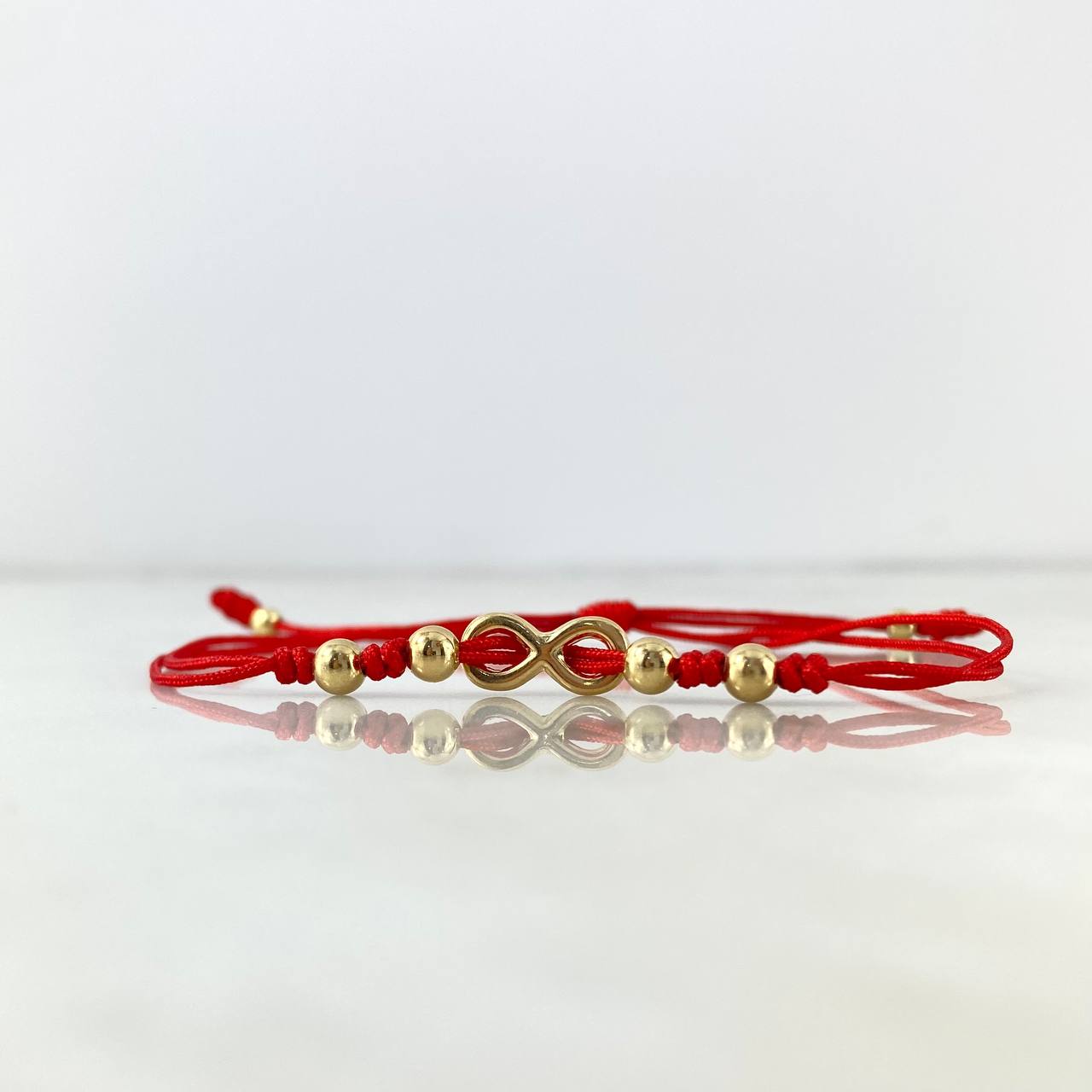 Pulsera Roja Infinito Atravezado 0.8gr / 4mm-3mm Bolas Lisas 6 und Oro Amarillo *