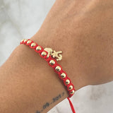 Pulsera Roja Dije Tres Gracias 1.65gr / 4mm Bolas Lisas 12 und Oro Amarillo 18K  ©