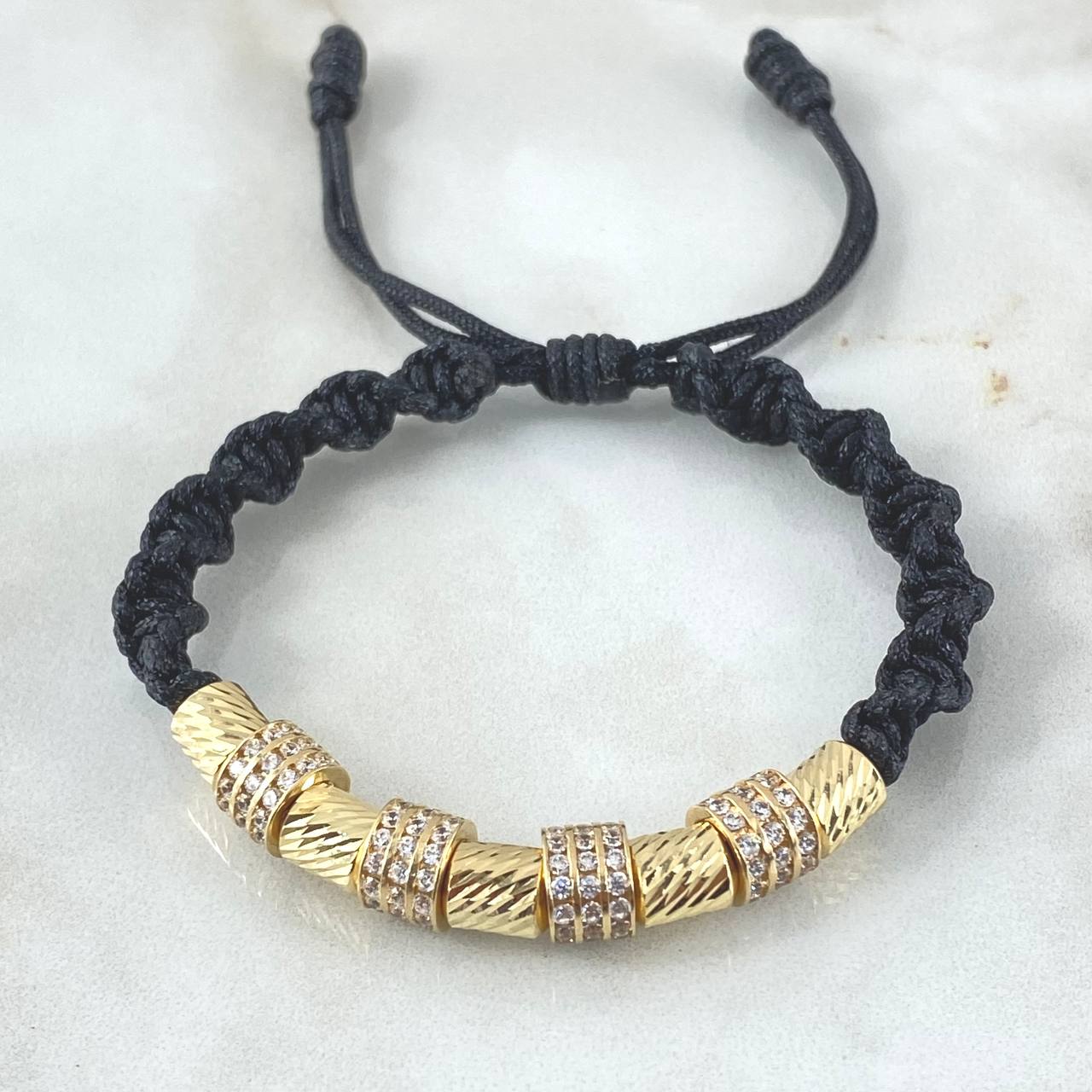Pulsera Negra Herraje Rueda Triple Circones Blancos 6.1gr / 6mm Cilindros Diamantados 5und Oro Amarillo 18K ©