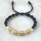 Pulsera Negra Herraje Rueda Triple Circones Blancos 6.1gr / 6mm Cilindros Diamantados 5und Oro Amarillo 18K ©