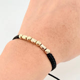 Pulsera Tejida Negra Cilindros Intercalados Bolas Diamantadas Oro Amarillo 18K